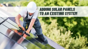 Man installing black-on-black solar panels on a roof. Title reads: "Why to Add More Solar Panels to Existing Solar Panel System"