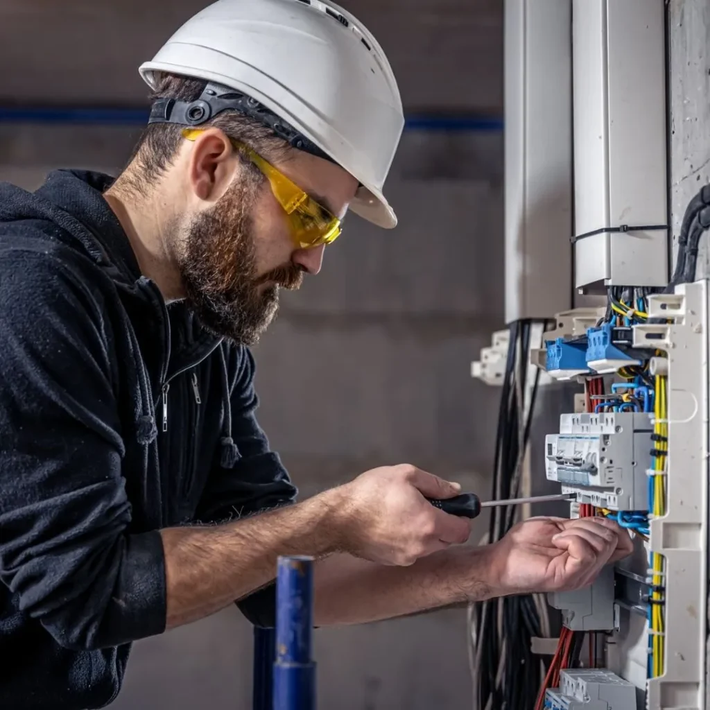 Electrician working on wires and electrical systems for solar panels and inverter system.